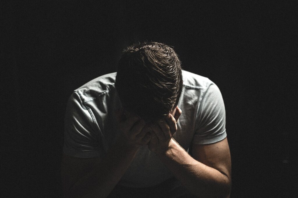 Distressed man with his head in his hands at a desk, conveying the emotional impact of wrongful termination